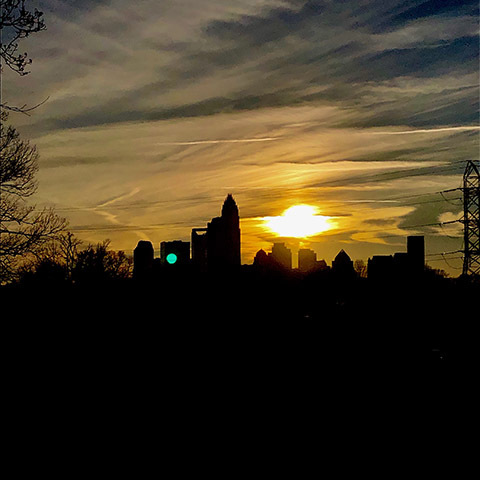 silhouette Charlotte city skyline at sunset