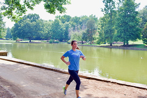 women running along pond on summer day